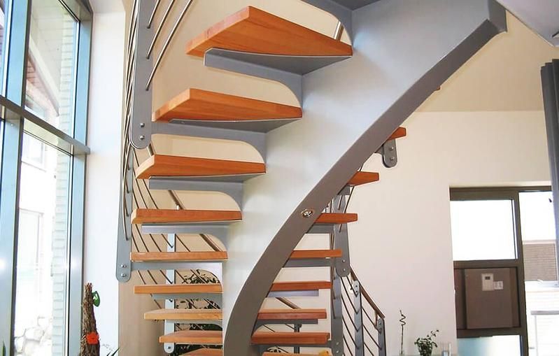 eine Wendeltreppe mit Holzstufen und einem Metallgeländer