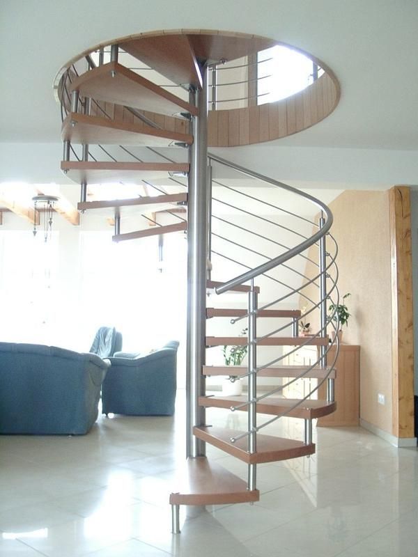 eine Wendeltreppe in einem Wohnzimmer mit blauen Stühlen