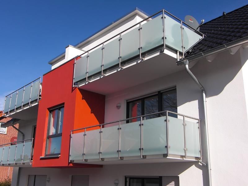 ein Gebäude mit einem Balkon und einer Satellitenschüssel auf dem Dach