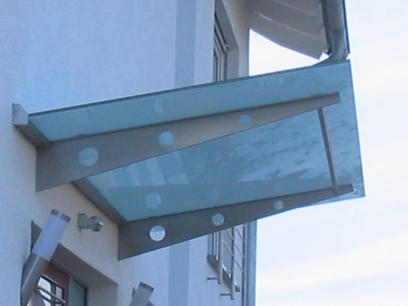 An der Seite eines Gebäudes wird ein Glasdach angebracht