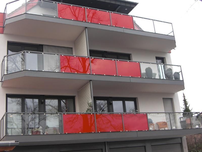 ein Gebäude mit vielen Fenstern und roten Balkonen