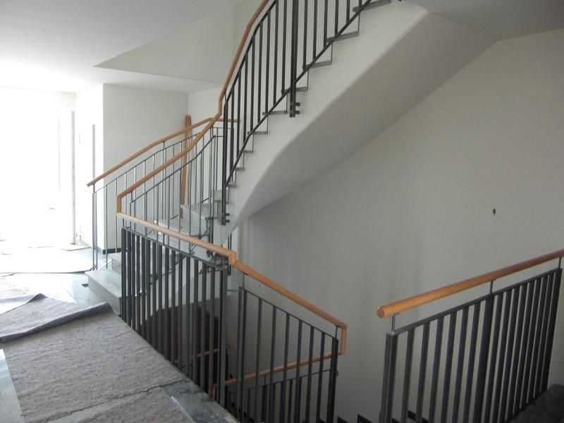 eine Treppe mit Metallgeländer und Holzhandläufen