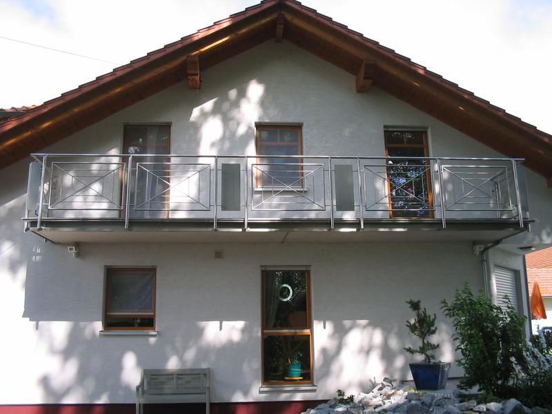 ein weißes Haus mit einem Balkon und einem Fenster mit der Nummer 5 darauf