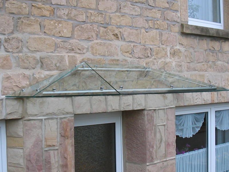 ein Backsteingebäude mit einem Glasdach über der Tür