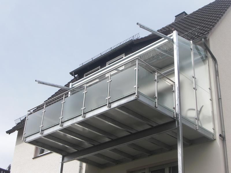 ein Balkon an der Seite eines Gebäudes mit einem klaren Glasgeländer