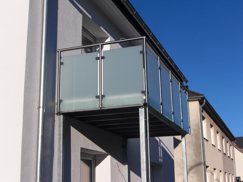 ein Balkon an der Seite eines Gebäudes mit einem blauen Himmel im Hintergrund