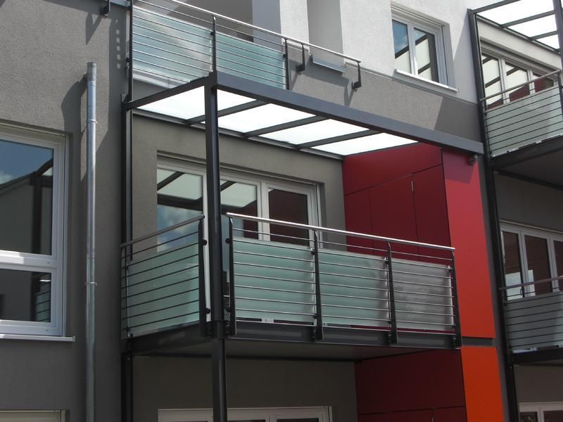 ein Balkon an der Seite eines Gebäudes mit einem Glasgeländer