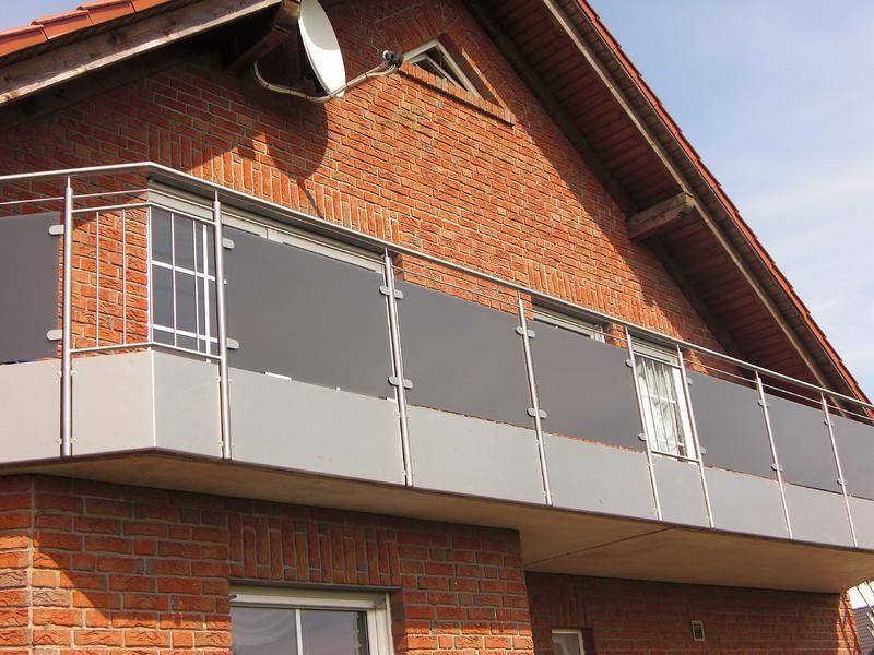 ein Backsteingebäude mit Balkon und einer Satellitenschüssel auf dem Dach