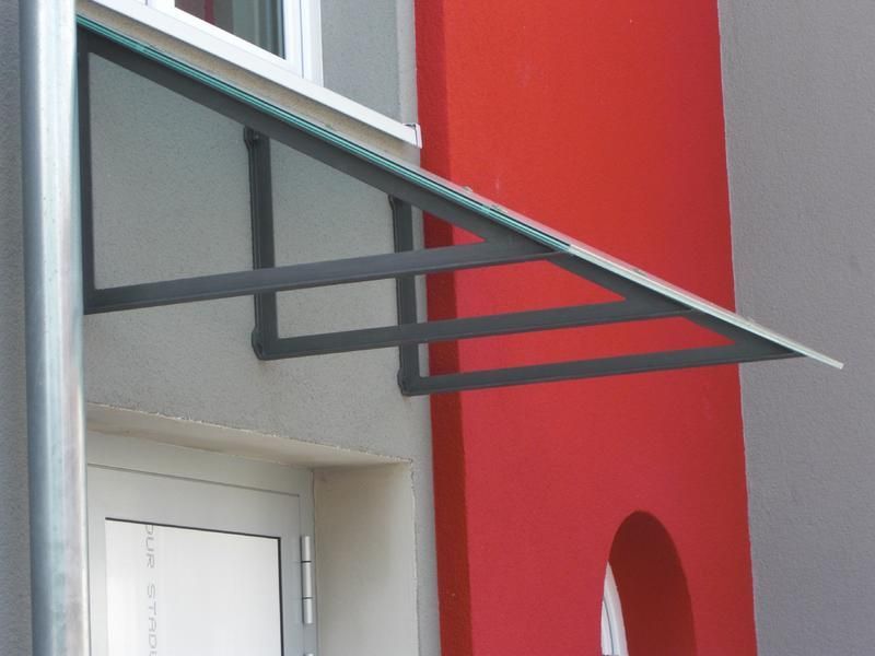 ein rot-graues Gebäude mit einem Vordach über der Tür