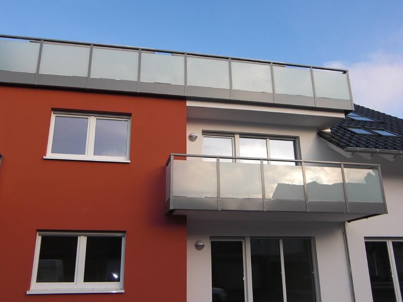 ein rot-weißes Gebäude mit einem Balkon im zweiten Stock