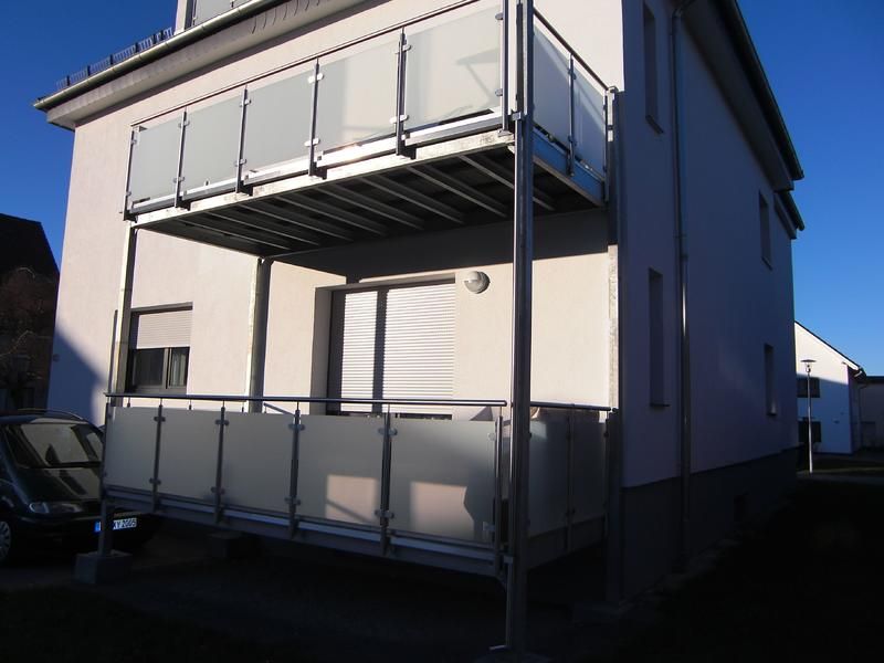 ein weißes Haus mit einem Balkon an der Seite