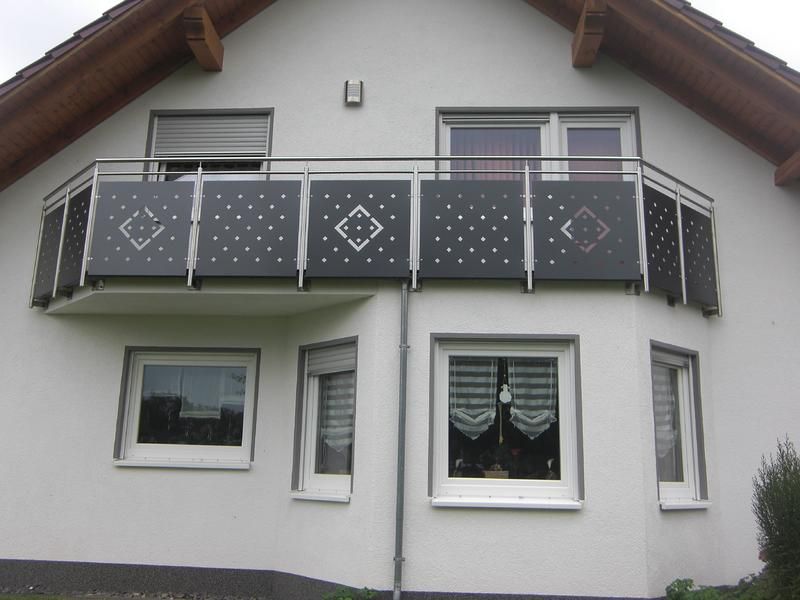 ein weißes Haus mit Balkon und Fenstern