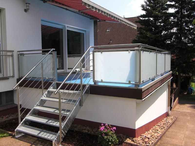 ein weißes Haus mit einer Treppe, die zu einem Balkon führt