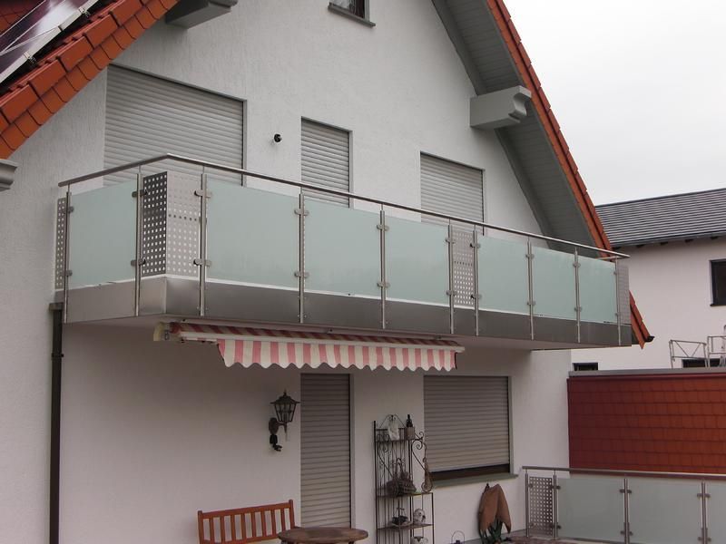ein weißes Haus mit einem Balkon mit Edelstahlgeländer