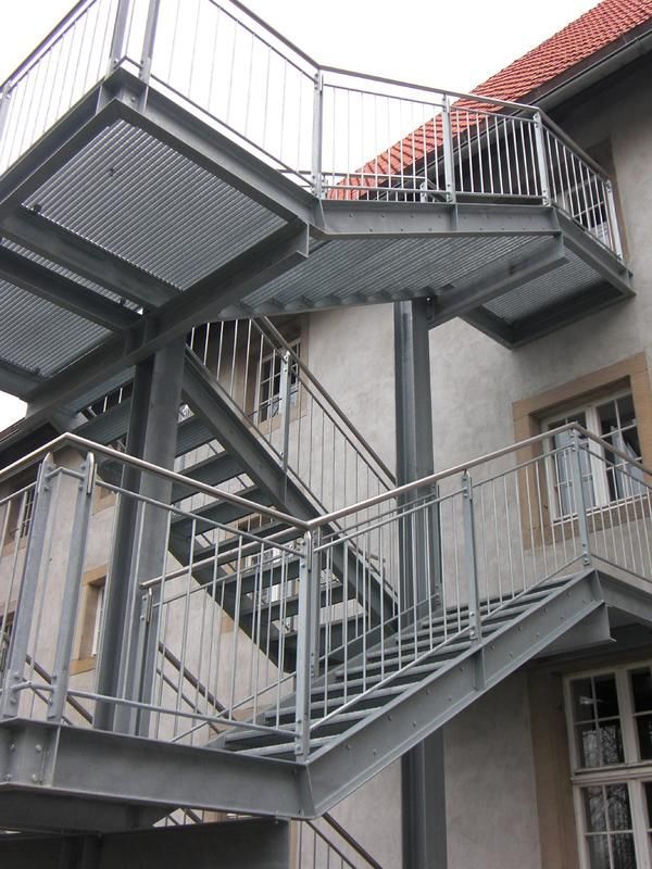 eine Treppe, die zu einem Balkon an der Seite eines Gebäudes führt