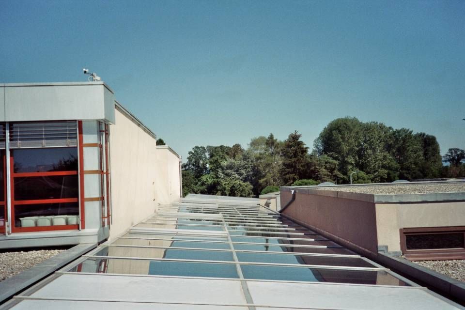 Un bâtiment avec un toit qui a beaucoup de fenêtres