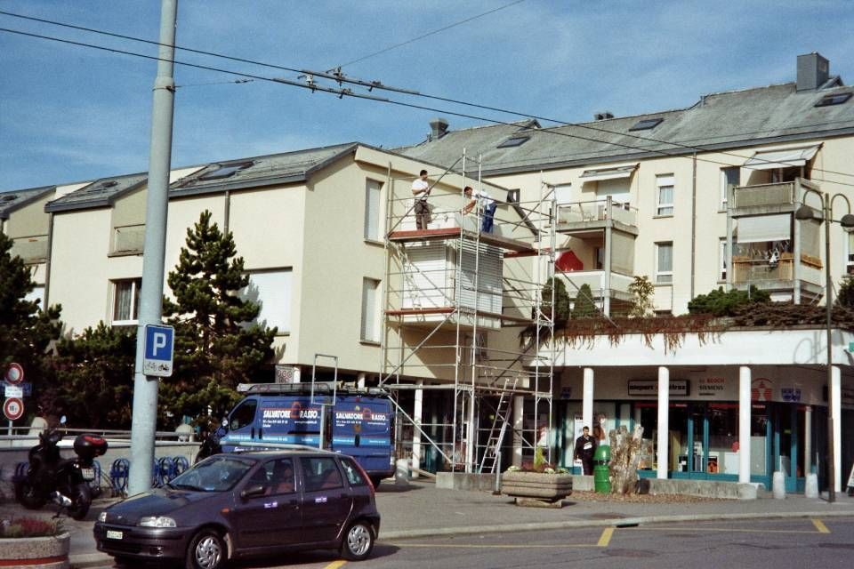 Une voiture est garée devant un bâtiment avec la lettre p sur un poteau