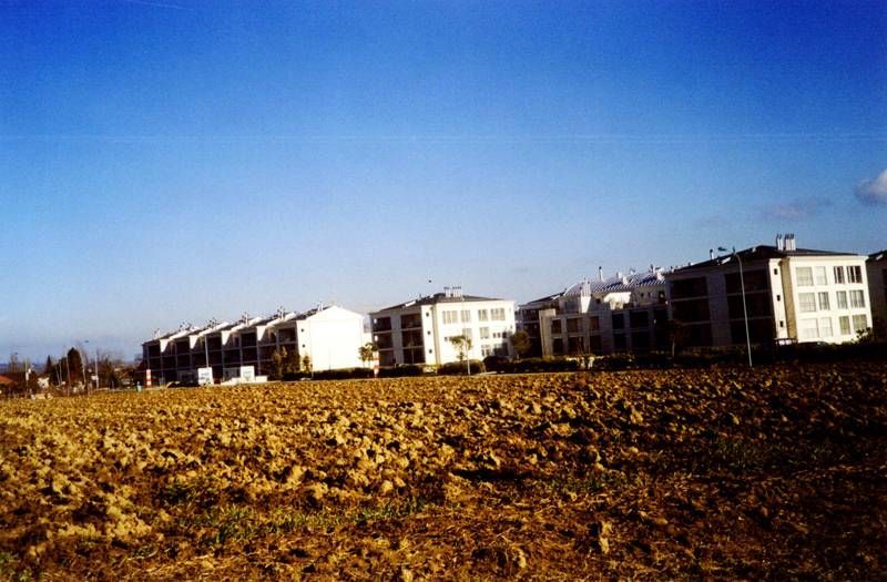 Un champ avec une rangée de bâtiments en arrière-plan