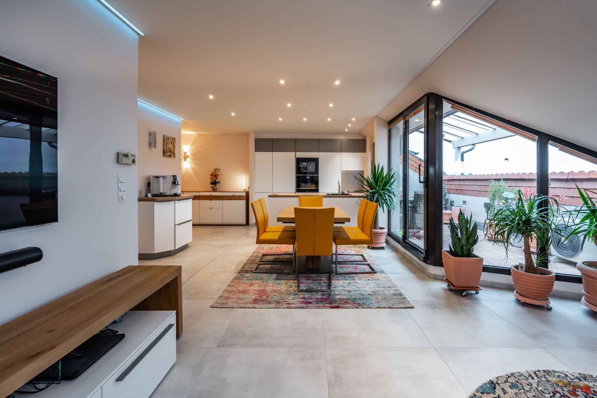 Weitwinkel eines Wohn- und Essbereiches mit Schrägdach und weißer Decke