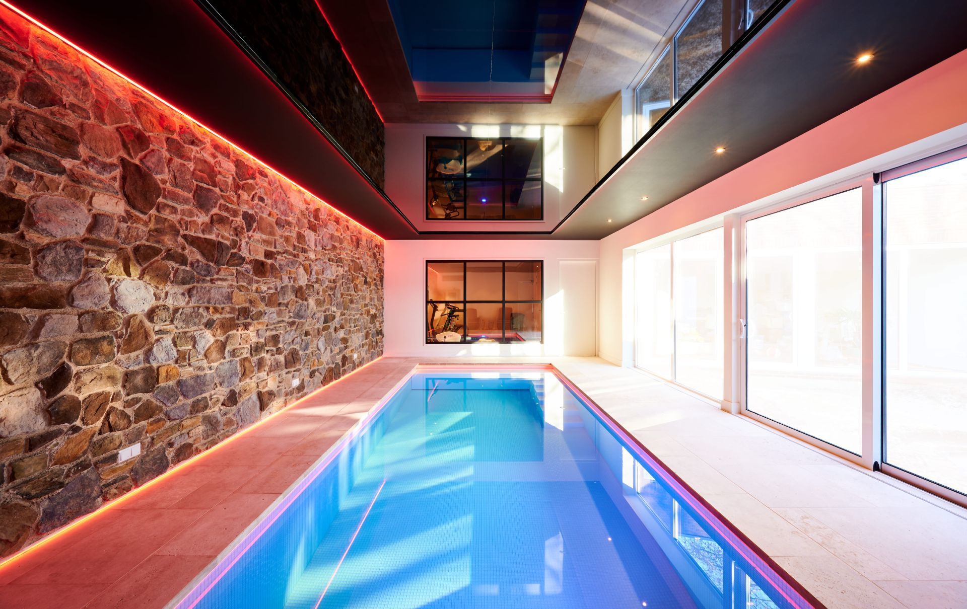 Ein weiter Indoor-Pool mit schwarzer Decke und LEDs