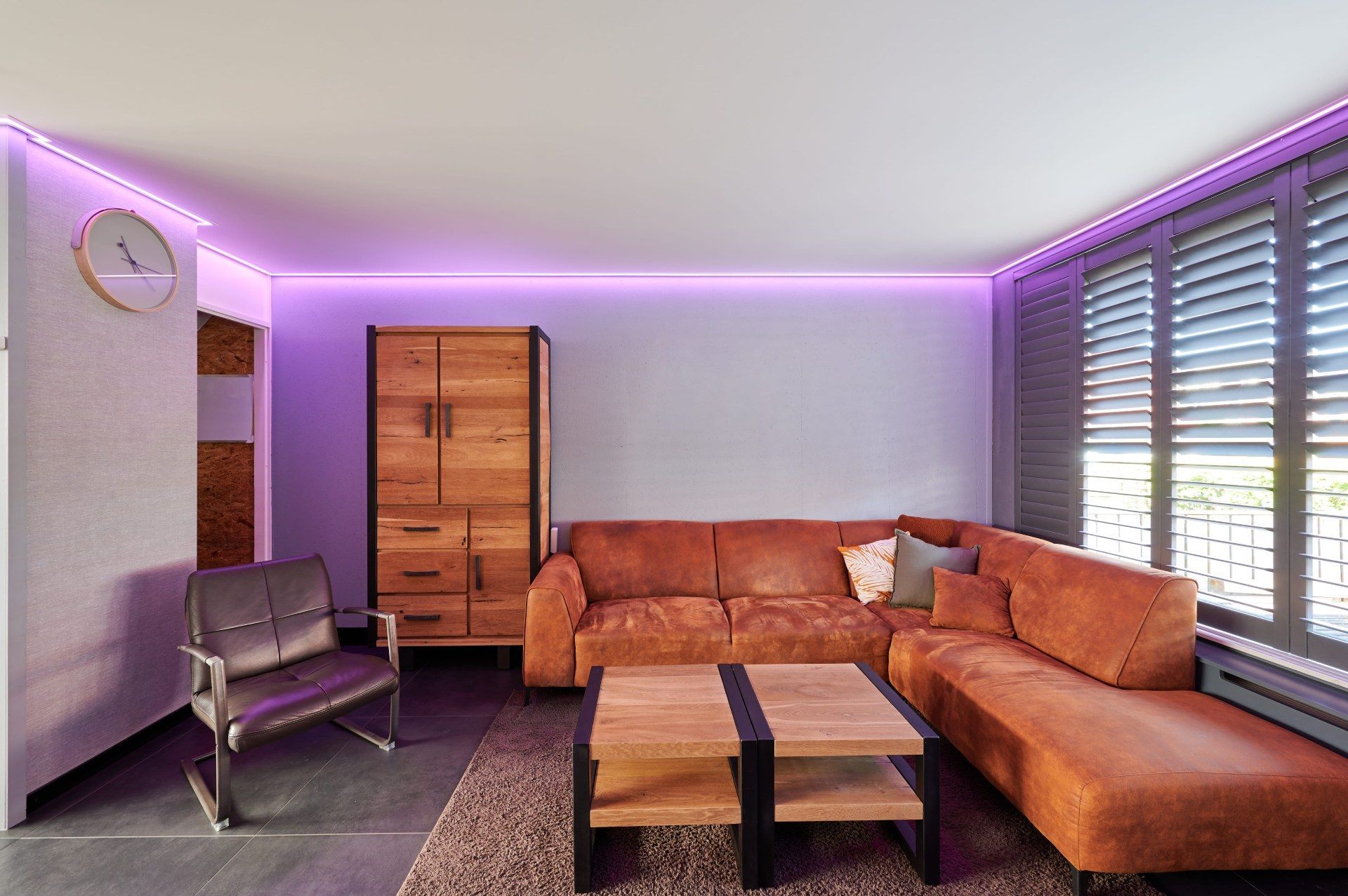 kleines Wohnzimmer mit weißer Decke und lilafarbenden LEDs