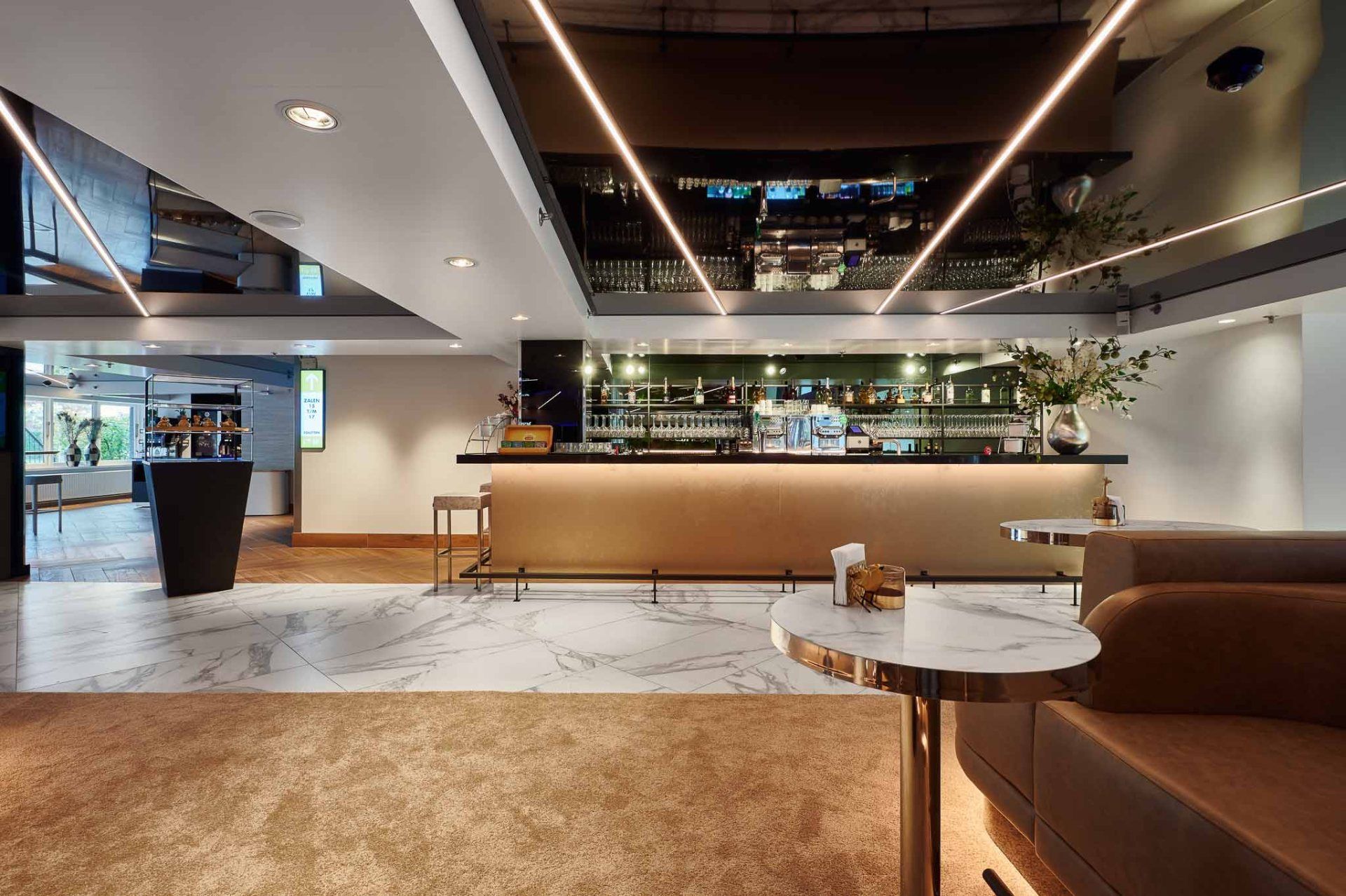 Eine Bar mit einem Deckenspiegel und langen, schmalen Lichtern