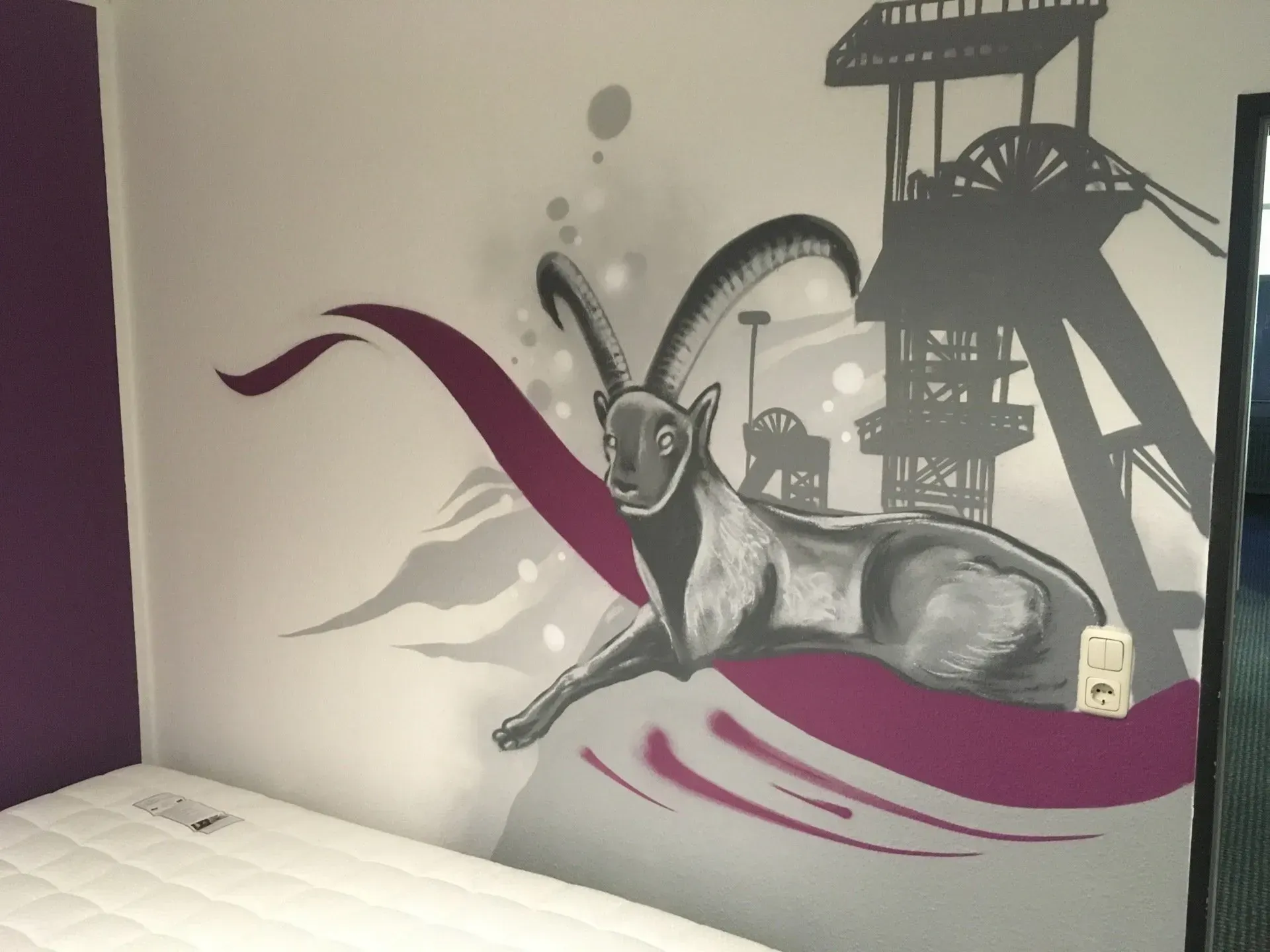 Ein Gemälde einer Ziege an einer Wand neben einem Bett