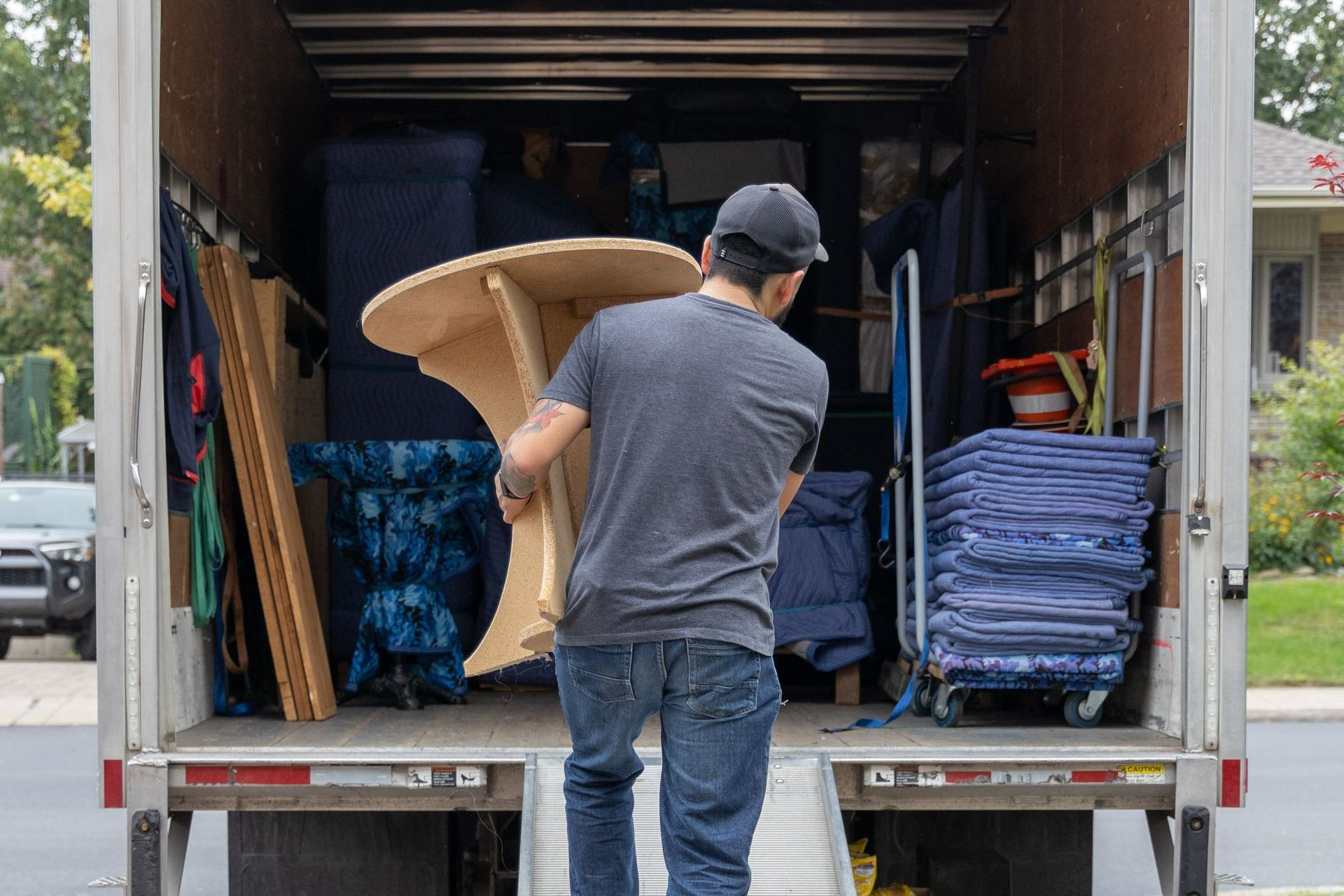 Déménageur en train de charger une table dans un camion