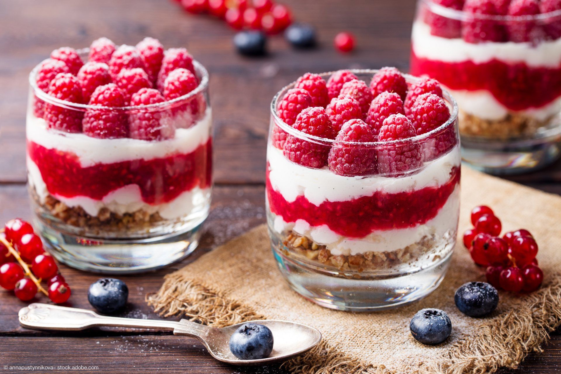 Himbeerdessert geschichtet im Glas, mit Müsli, Joghurt, Himbeersauce und frischen Himbeeren