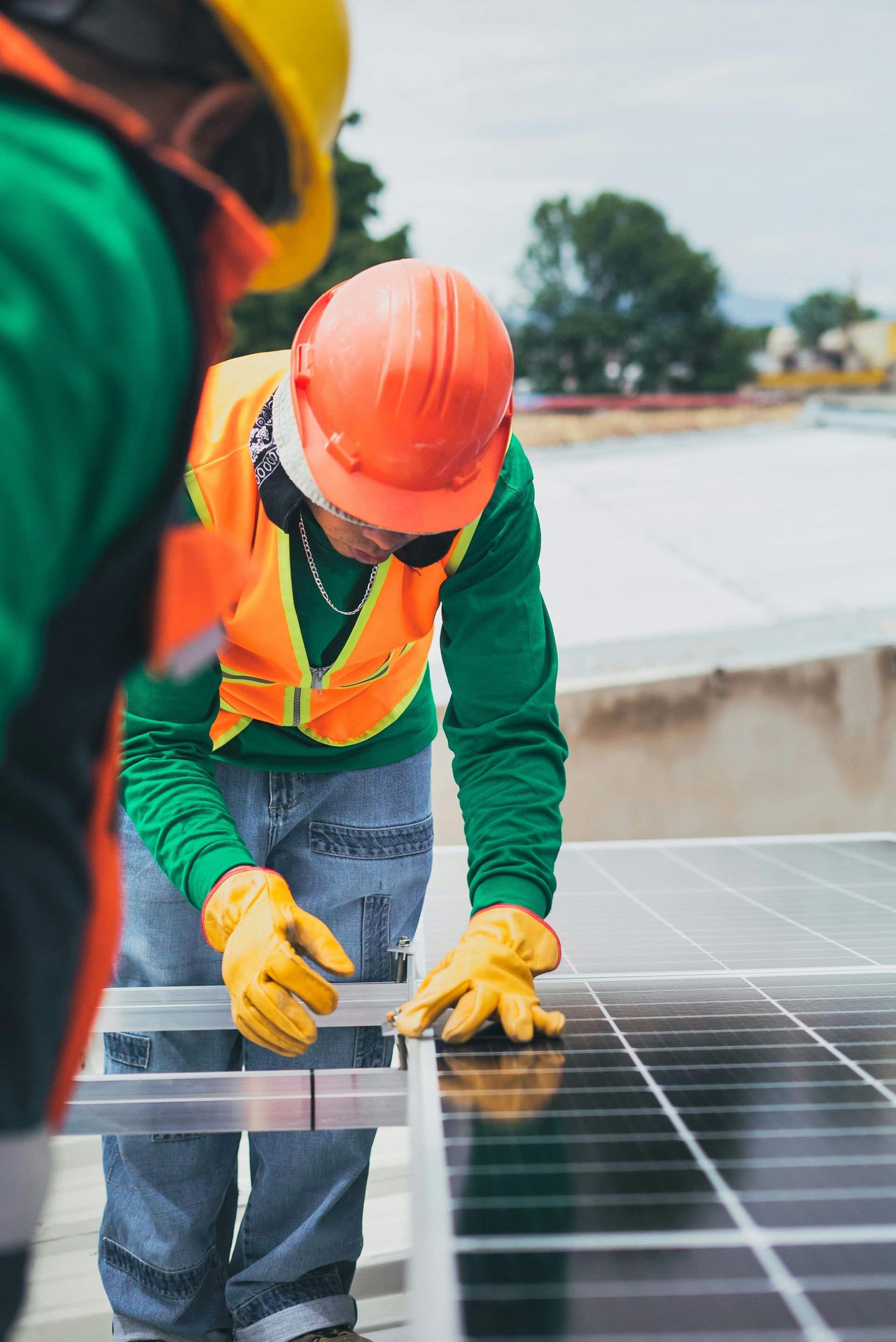 Dos hombres están trabajando en un panel solar en un tejado.