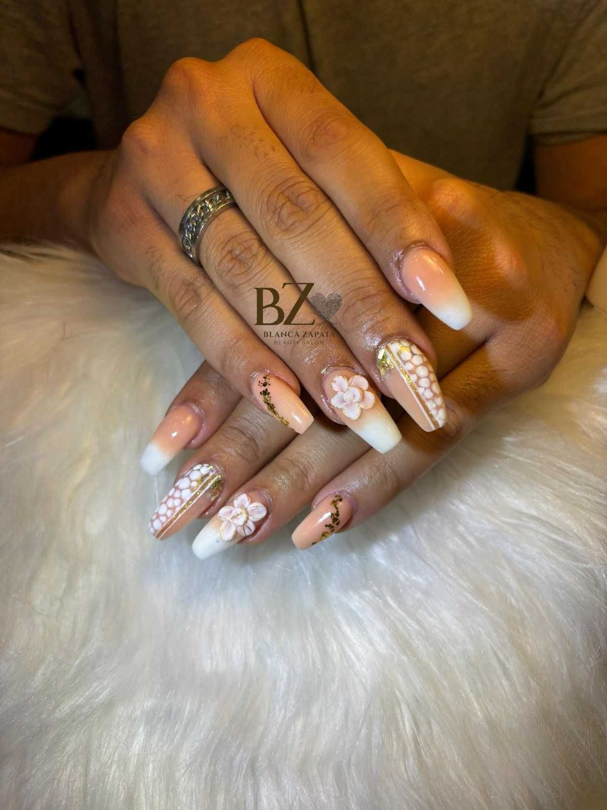 Manos bien cuidadas con uñas color nude y con purpurina descansando sobre piel blanca.