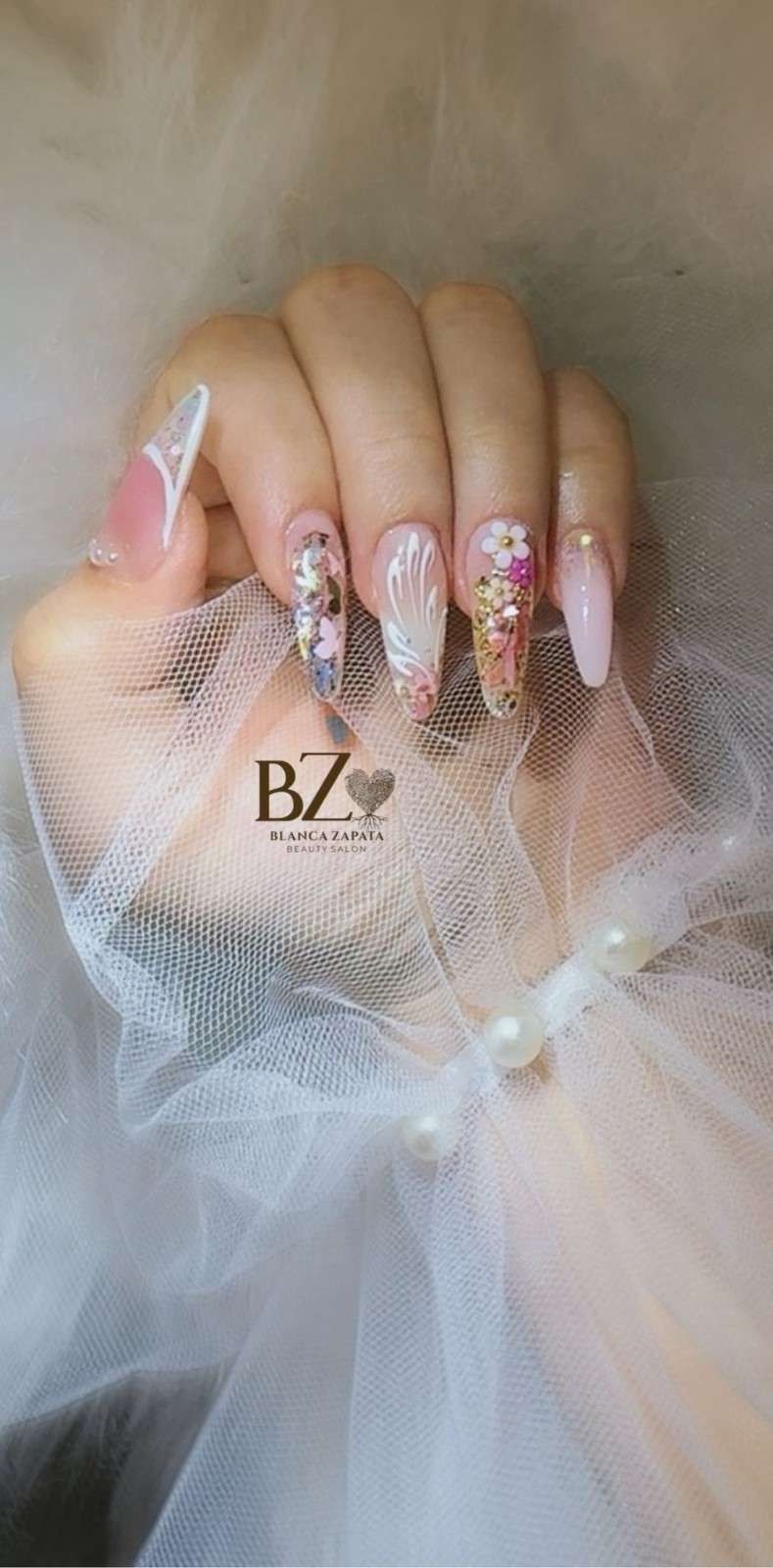 Mano con uñas largas de color rosa 