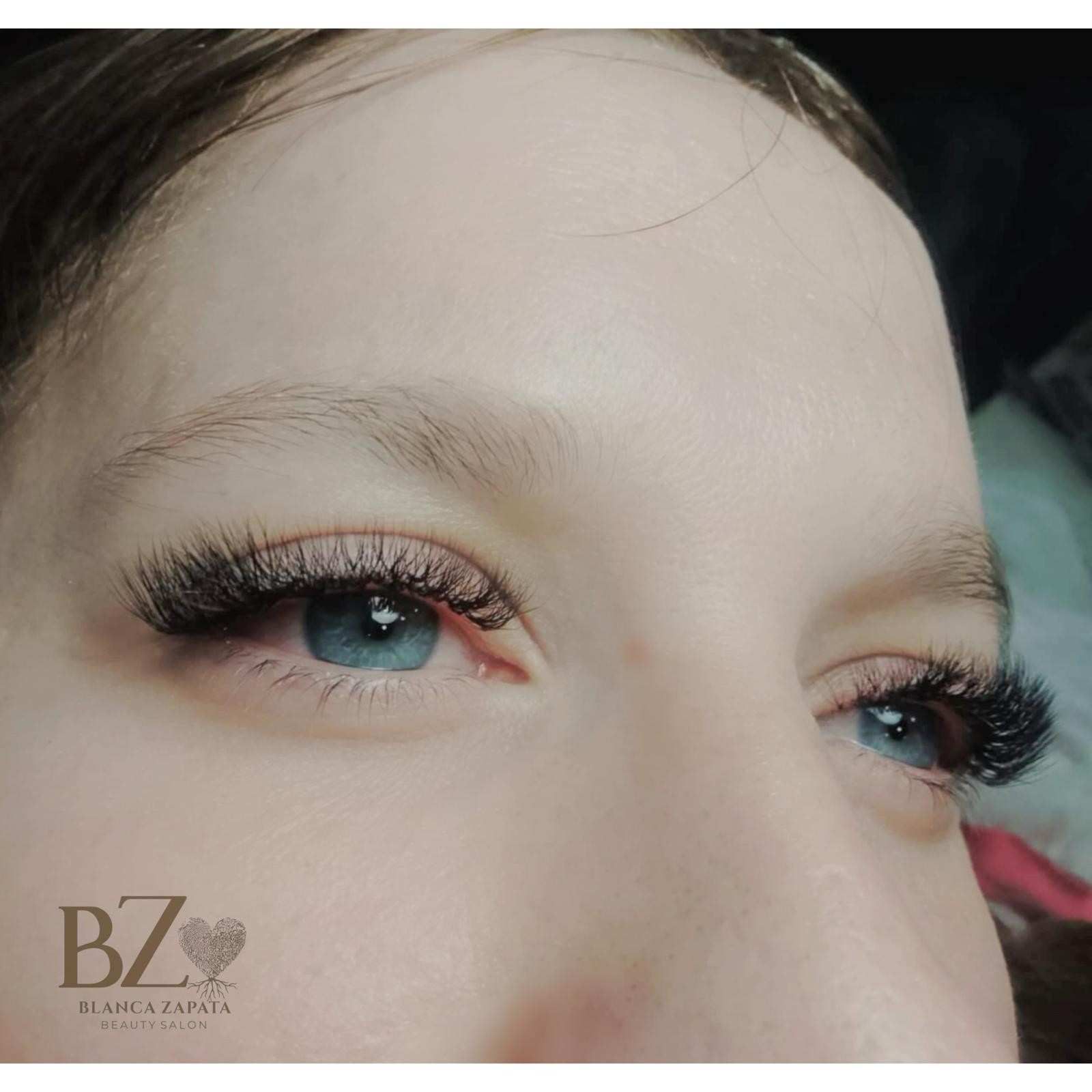 Primer plano de ojos con largas pestañas postizas e iris azules, con una pequeña marca de agua BZ en la esquina.