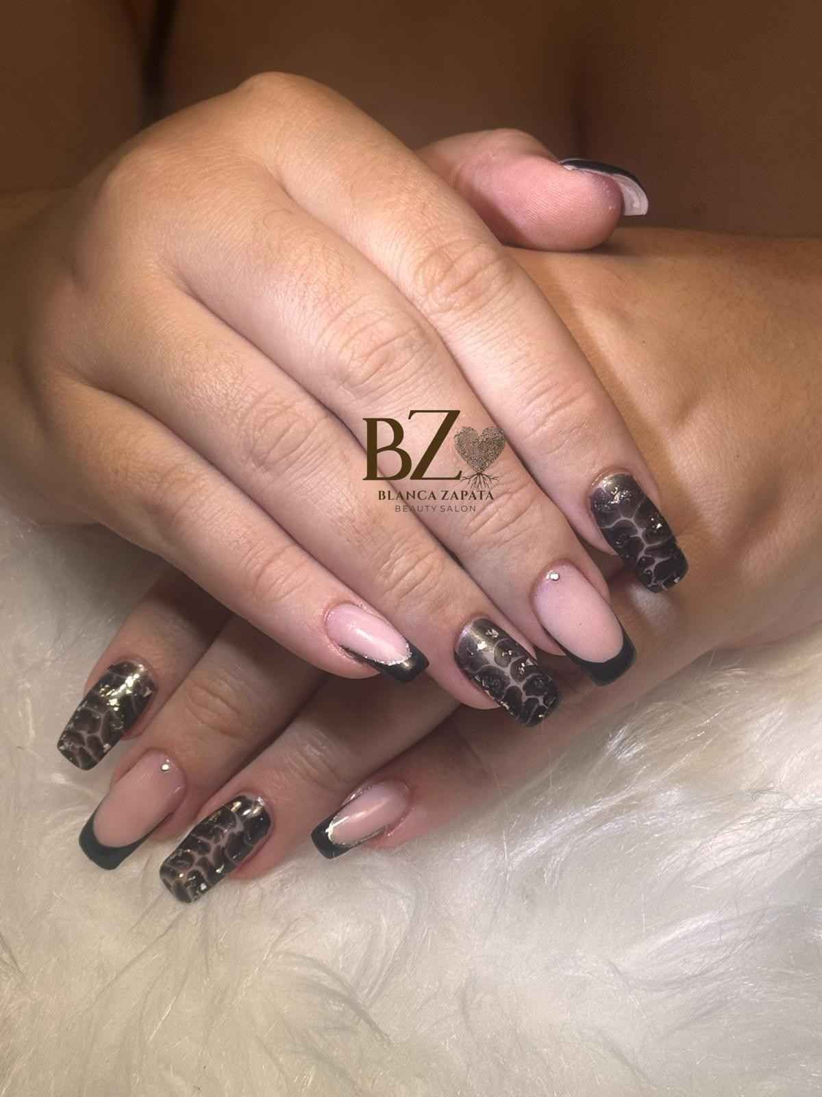 Manos con uñas rosas y negras brillantes descansando sobre una superficie de piel blanca.