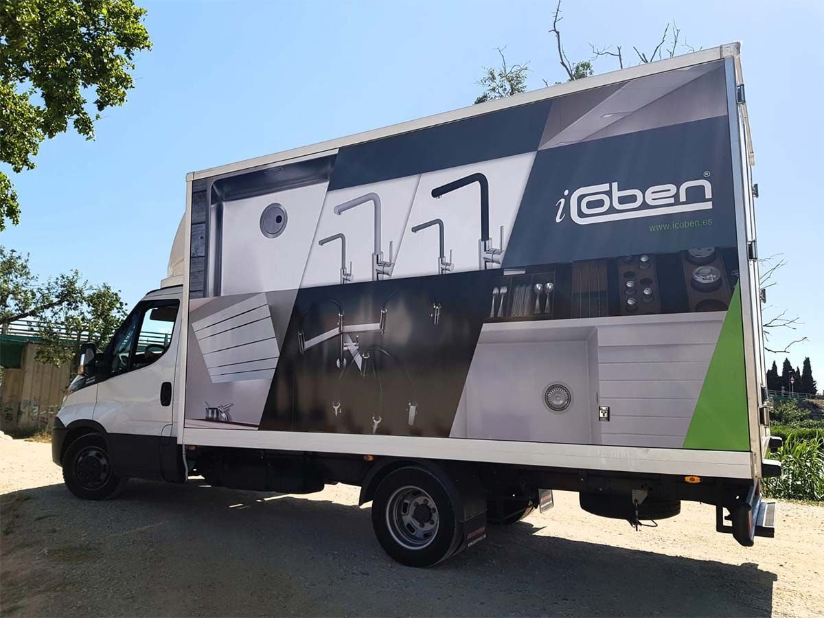 Un camión blanco con detalles en negro, que presenta un gran anuncio de accesorios de cocina 