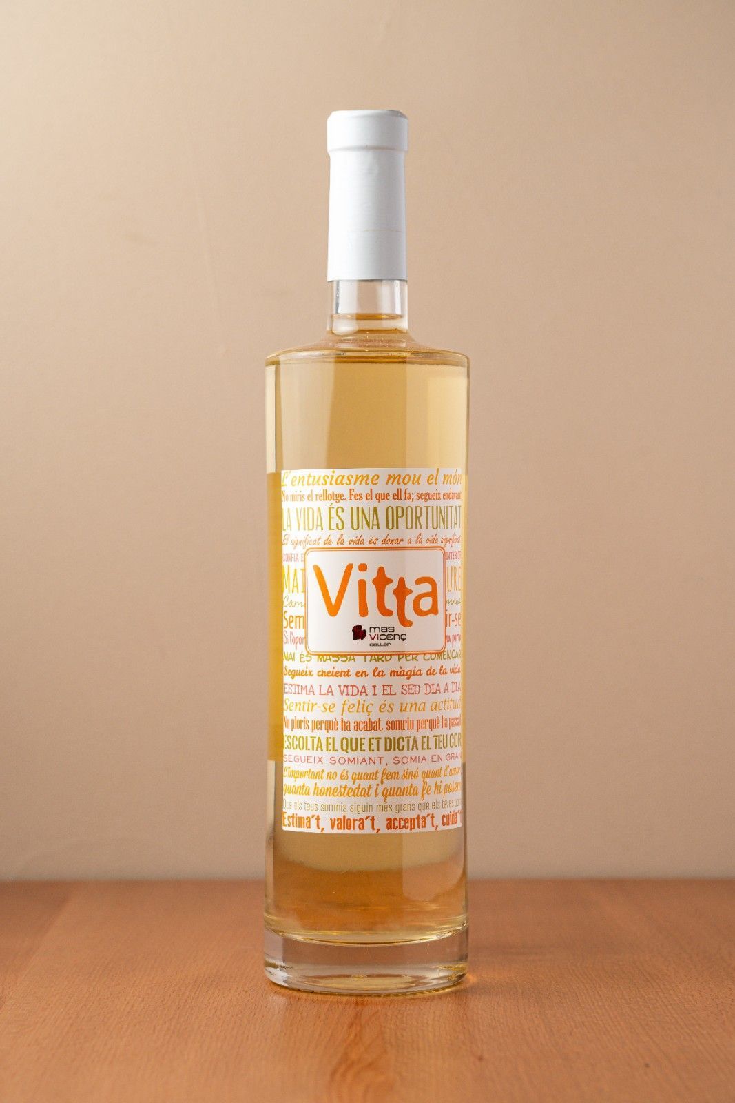 Botella alta de vidrio con líquido ámbar y tapón blanco sobre una superficie de madera sobre un fondo beige.