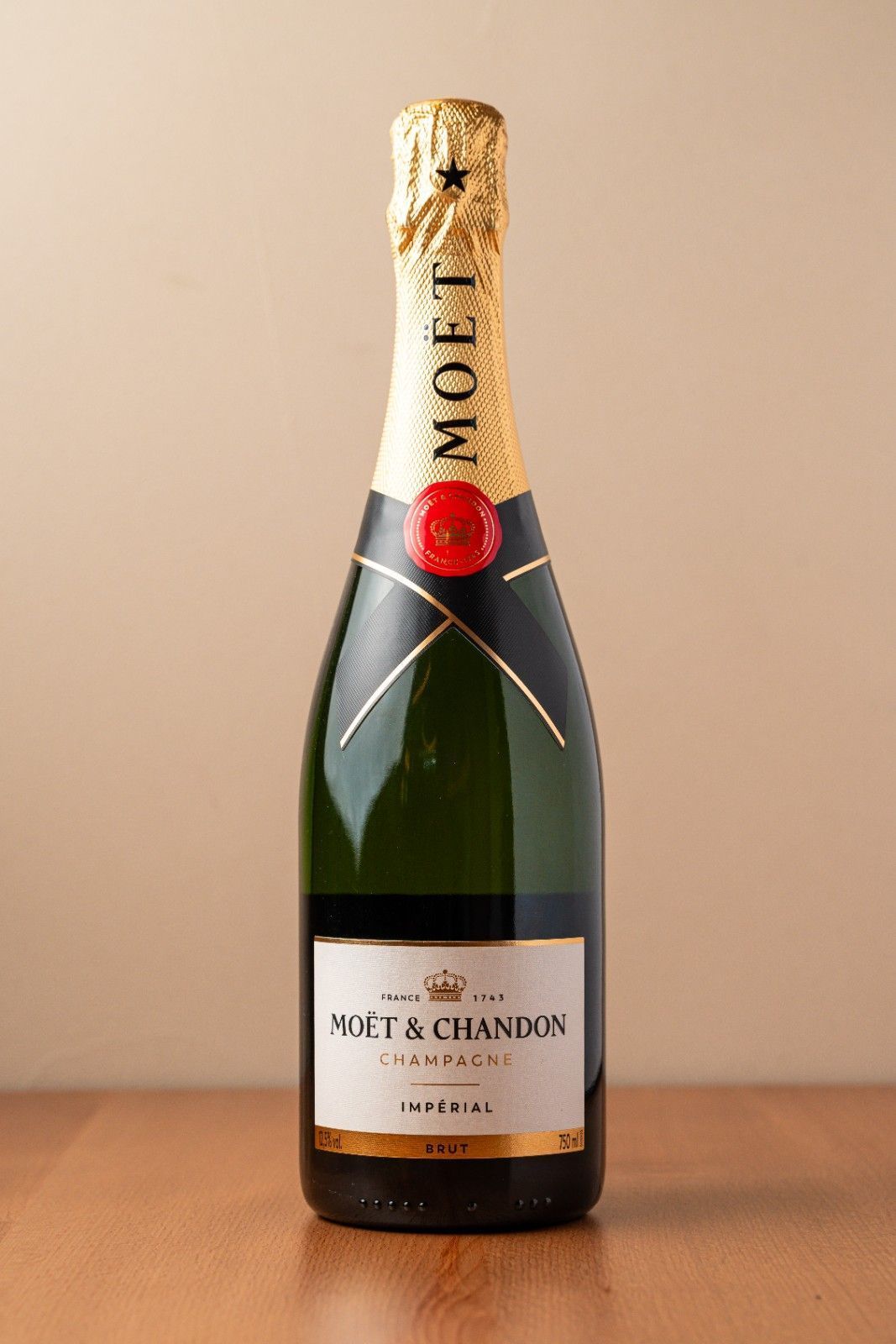 Una botella de champán Moët & Chandon sobre una mesa con fondo liso.