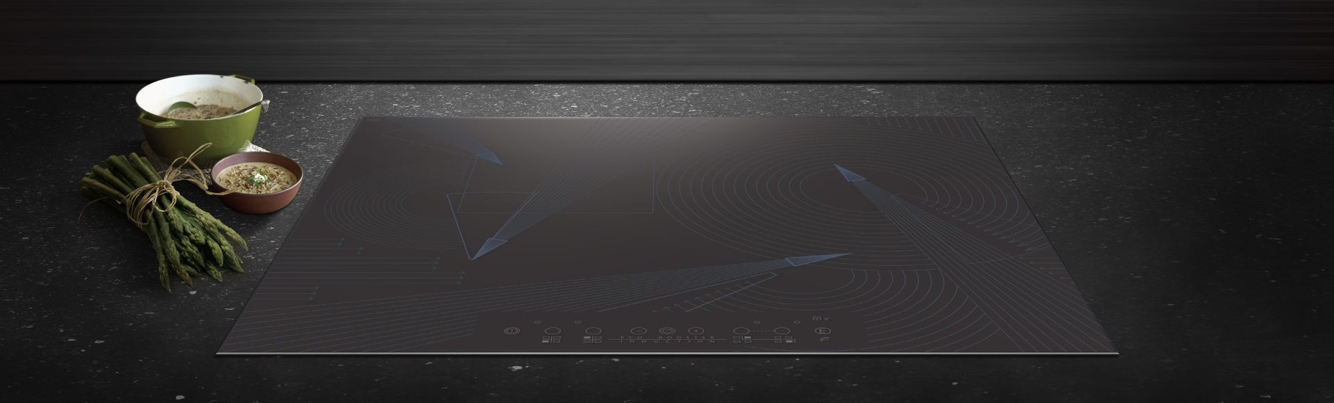 Auf einer schwarzen Arbeitsplatte steht ein Herd mit Backofen neben einer Schüssel Suppe und einem Bund grünen Bohnen.