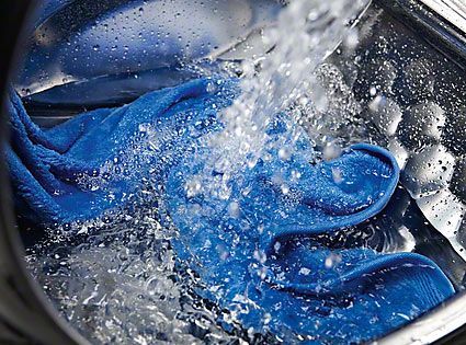 Ein blaues Handtuch wird in einer Waschmaschine gewaschen.