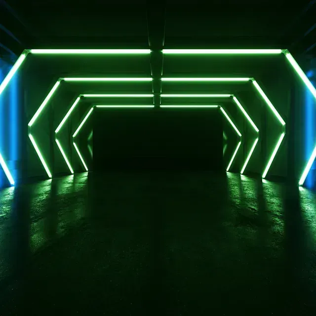Luces geométricas de color verde neón y azul iluminan un túnel oscuro y de aspecto húmedo.