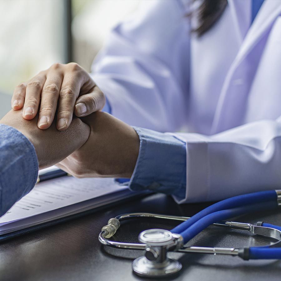 Un médico sostiene la mano de un paciente.