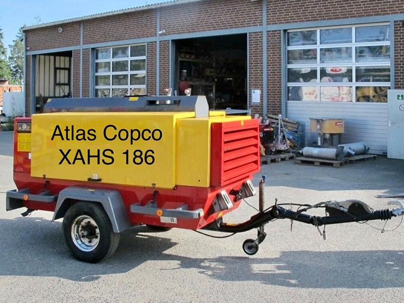 Ein gelb-roter Atlas Copco XHS 186-Anhänger