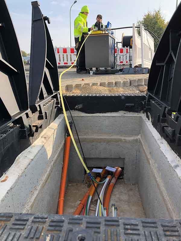Ein Mann arbeitet an einer Brücke, aus der ein Haufen Kabel herausragt.