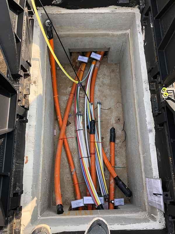 Eine Betonbox voller elektrischer Leitungen und Kabel.