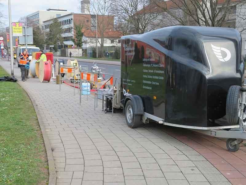 Ein schwarzer Anhänger steht am Straßenrand