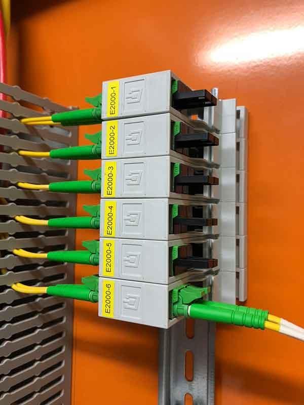 Ein Bündel grüner und gelber Drähte ist mit einer Wand verbunden.