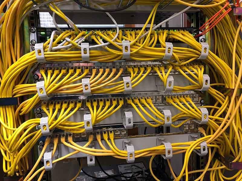 Ein Bündel gelber Kabel ist mit einem Server verbunden.