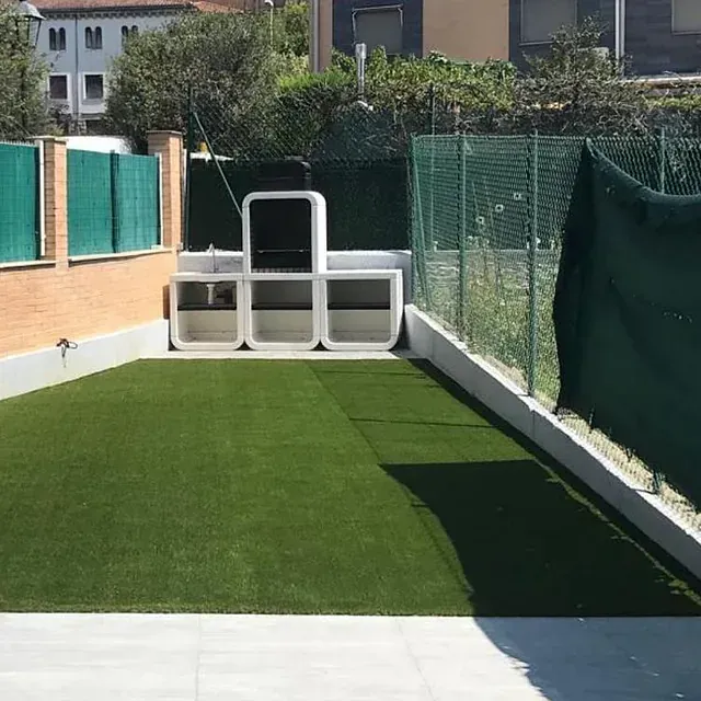 Una valla verde rodea un exuberante césped verde.