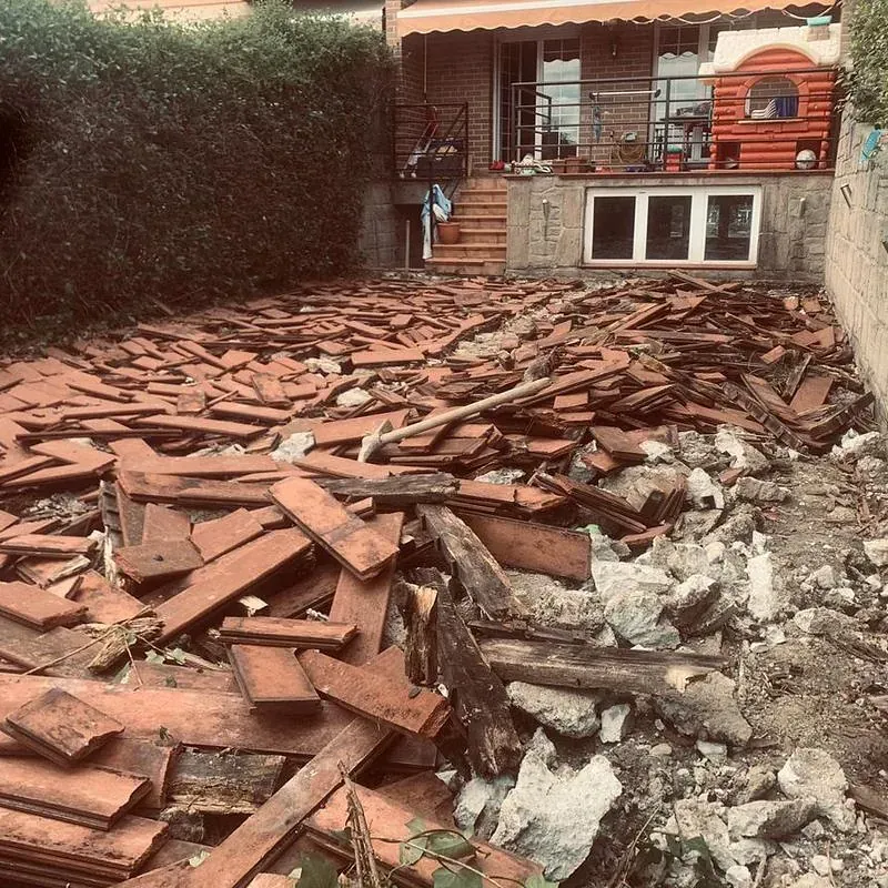 Una pila de madera y piedras delante de una casa