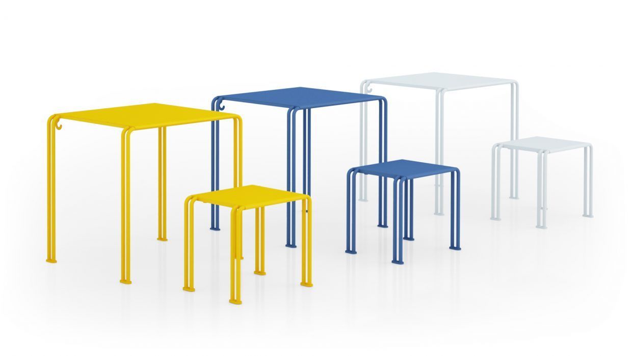 Un grupo de mesas y taburetes de colores sobre un fondo blanco.